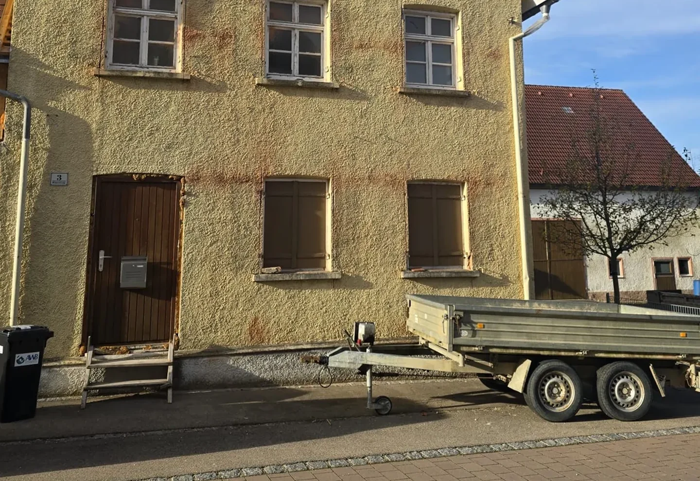 Vorher: Erdgeschoss eines Altbaus mit alten Fenstern und Klappläden